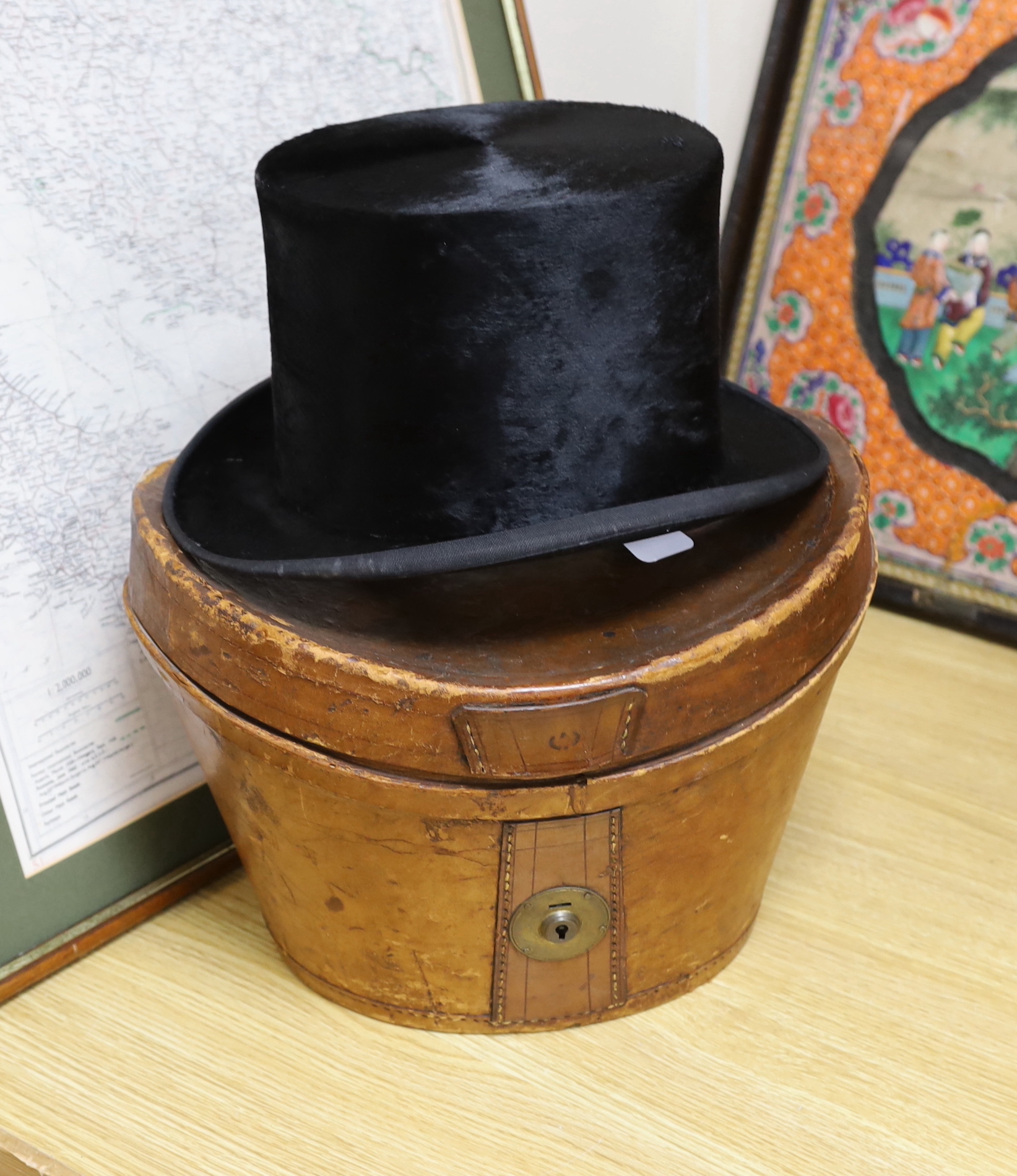 A brown leather case and top hat, hat box 24cm high